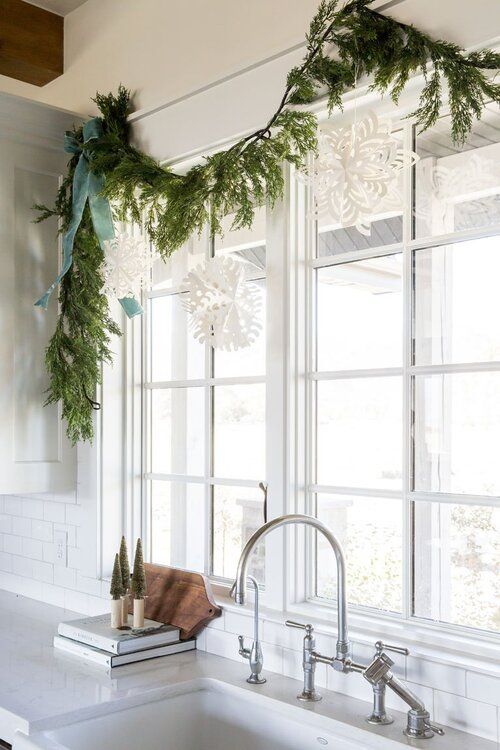 White kitchen window with garland and paper snowflakes