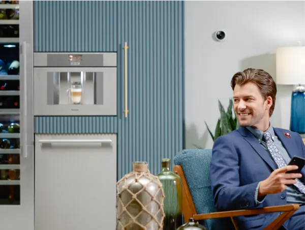 man sitting next to Thermador coffee machine