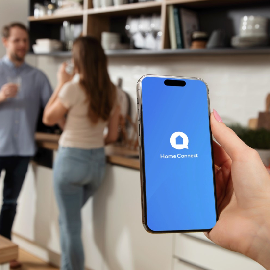 A woman checks status in Home Connect app. 