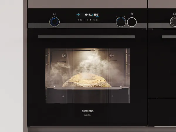 Et dampende brød hæver sig i en elegant sort Siemens ovn med en digital skærm og dobbelt kontrolknapper.