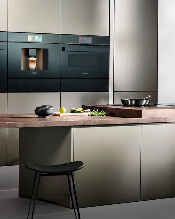 Siemens kitchen featuring sleek dark appliances, a wooden countertop with herbs and limes.