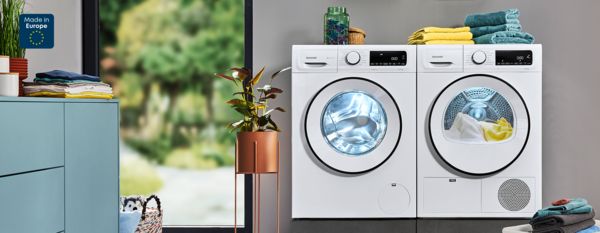 Moderne Küche mit Waschmaschine, Trockner und Wäschekorb.