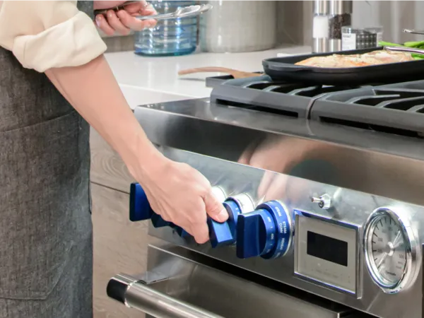 Thermador blue knobs accessory woman turning blue knob on range