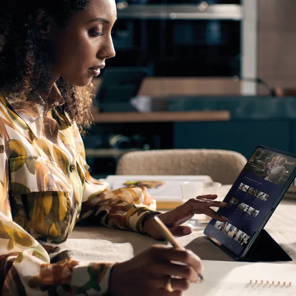 Person at a table planning a kitchen on a tablet