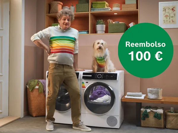 Hombre con suéter de rayas junto a una lavadora moderna y un perro en un suéter colorido. Un círculo verde muestra un reembolso de 100 €.
