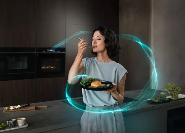 Una joven disfruta del sabor de un plato recién cocinado en un horno Siemens