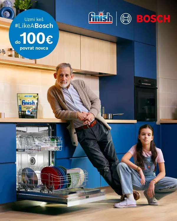 Stariji čovjek i djevojčica stoje ispred otvorene perilice posuđa u modernoj kuhinji.