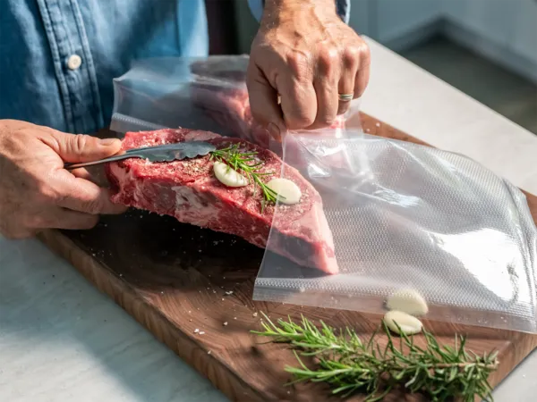 person placing steak in sous vide compatible bag