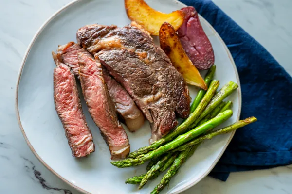 thermador air sous vide mode medium rare steak plated next to blue napkin