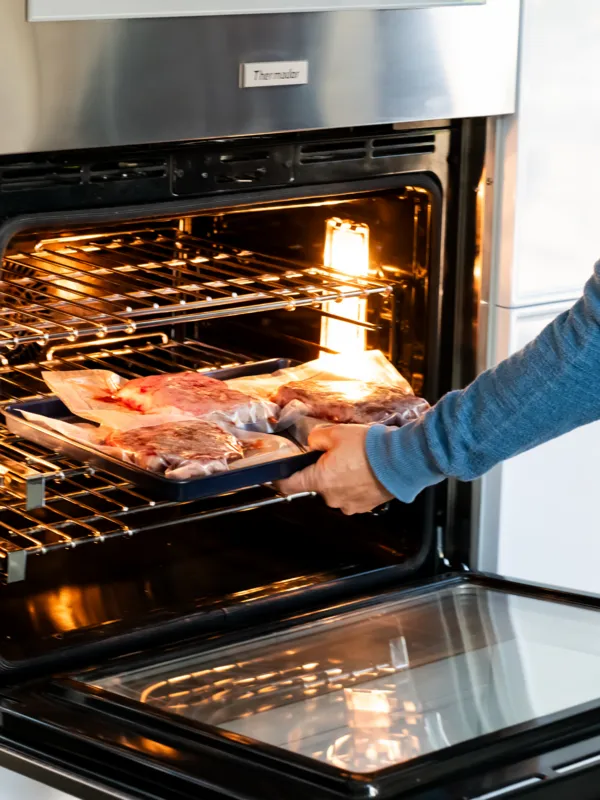 thermador air sous vide mode man pulling out baking pan out of oven