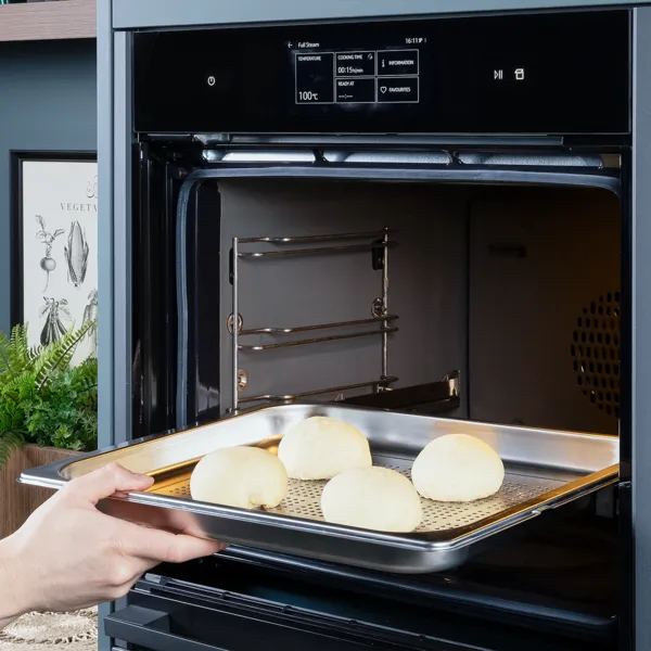 Den Backofen auf 100 °C Full Steam vorheizen. Die Klöße auf ein Backblech legen und in den Backofen schieben. Für ca. 15 Minuten dämpfen. Die übrige Butter in einem kleinen Topf zerlassen und zur Seite stellen. Puderzucker und Mohn in einer kleinen Schüssel vermengen. Klöße mit Vanillesauce und etwas zerlassener Butter servieren. Mit der Mohn-Zucker-Mischung bestreuen und mit frischer Minze garnieren. Guten Appetit!