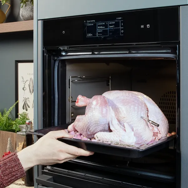 Schalotten auf einem Backblech mit einer ganzen rohen Pute.