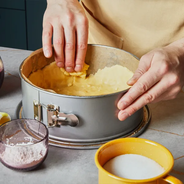 Den Teig in die Backform drücken.