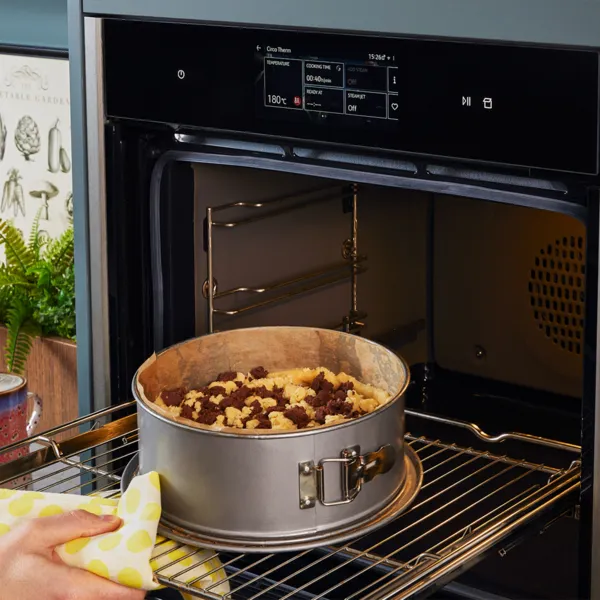 Den Kuchen in den Backofen schieben.