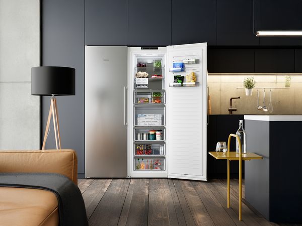 Un congelatore progettato da Siemens in una cucina moderna: &egrave; aperto e al suo interno si vedono i vari cassetti in perfetto ordine e la BigBox.