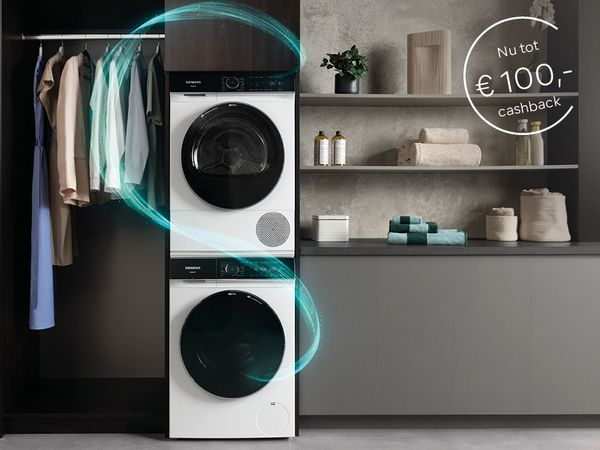 Een Siemens iQ700-wasmachine bovenop een iQ700-droger met de Siemens petrol glow, in een moderne wasruimte.