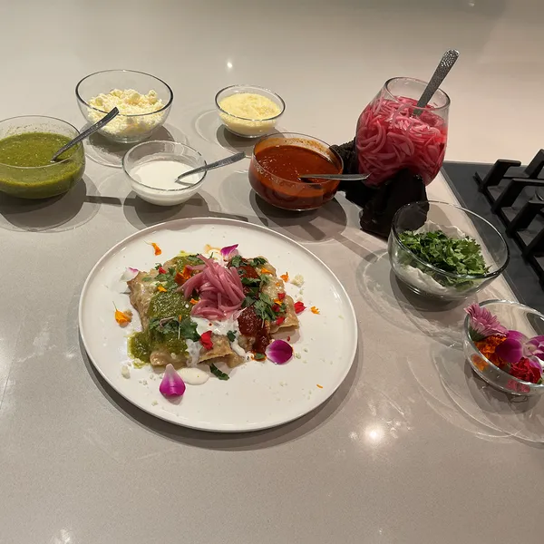 Colorful plate with various ingredients, including greens, pickled onions, and edible flowers.