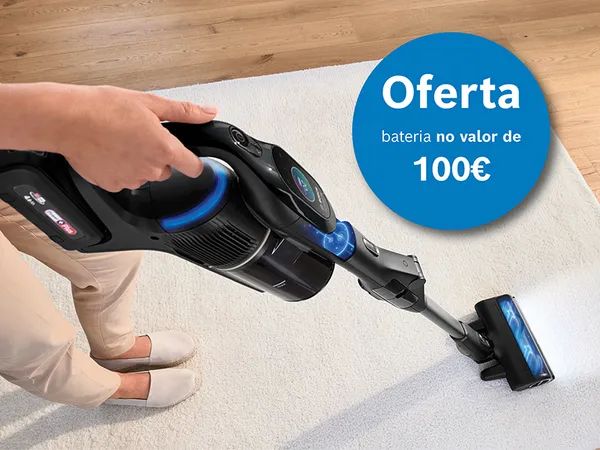 Mão a usar aspirador sem fios preto em tapete claro. Oferta azul de bateria de 100€.