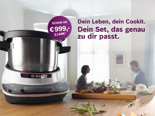 Bosch Cookit Küchenmaschine mit Kochfunktion auf einer Küchenarbeitsfläche neben einem zubereiteten Gericht. Im Hintergrund sitzen zwei Personen am Esstisch. Text: „Dein Leben, dein Cookit. Dein Set, das genau zu dir passt.“ Schon ab 999 € statt 1.099 €.