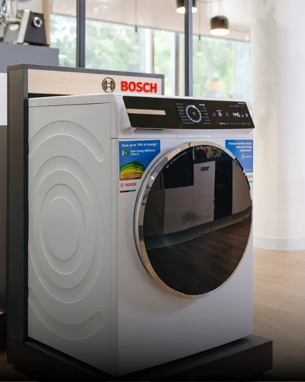 Egy Bosch mosógép és egy hozzá pódiumra állítva.