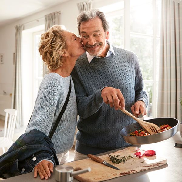 An elderly couple are getting to know the Home Connect functions and making the most of them whilst cooking.
