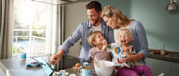 A family sitting on the sofa using the Home Connect app.