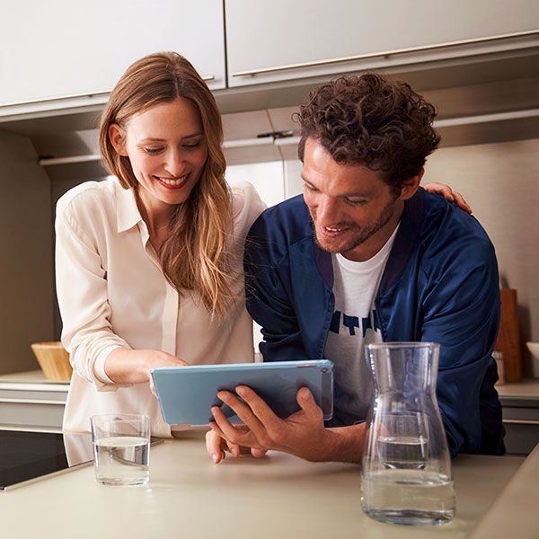 Um casal jovem a divertir-se com a aplicação Home Connect