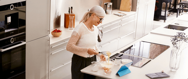 Εικόνα που δείχνει μια γυναίκα να μαγειρεύει με τη βοήθεια του Home Connect