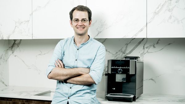 Inspiring Maker devant machine à café tout-automatique pose-libre EQ.9 plus connectée Home Connect Siemens.