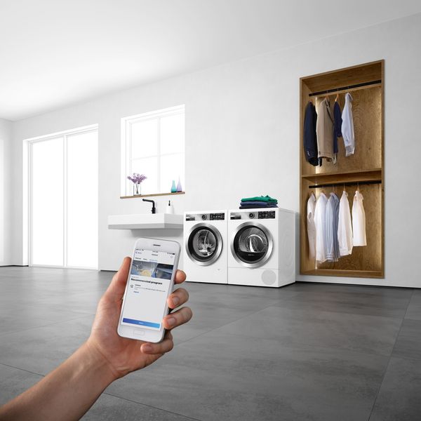 A woman checks status in Home Connect app. 