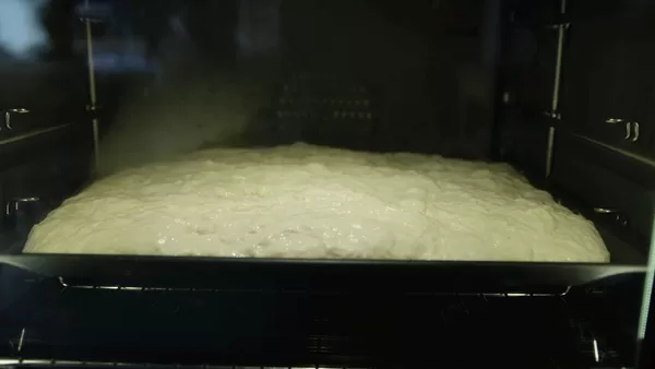 Tilsetter topping som oliven og urter på focaccia 