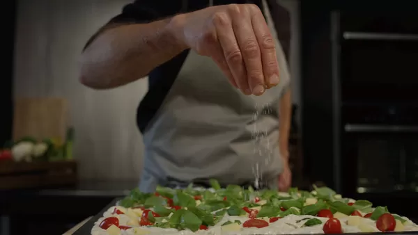 Focacciadeig hviler og hever på et brett 