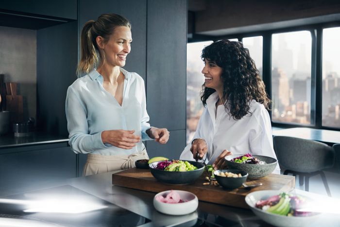 Due giovani amiche si rilassano in cucina ridendo