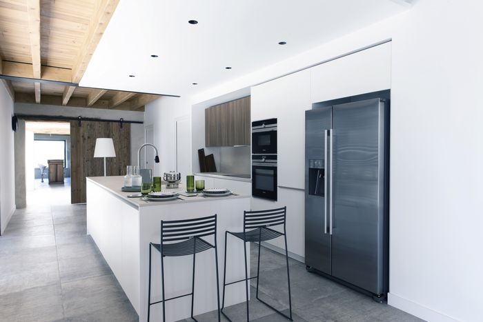 Cucina in stile americano con penisola multifunzionale, elettrodomestici a vista e dettagli in acciaio