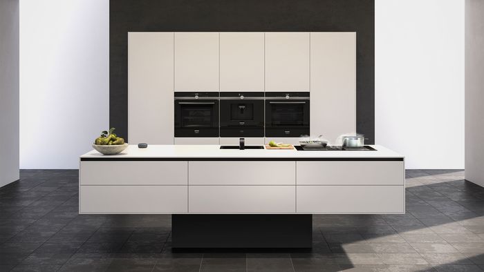 Monochrome kitchen including row of built in ovens