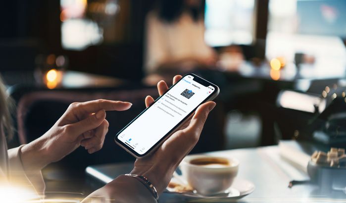 En una cafeter&iacute;a, una persona activa el funcionamiento de su electrodom&eacute;stico desde la app Home Connect