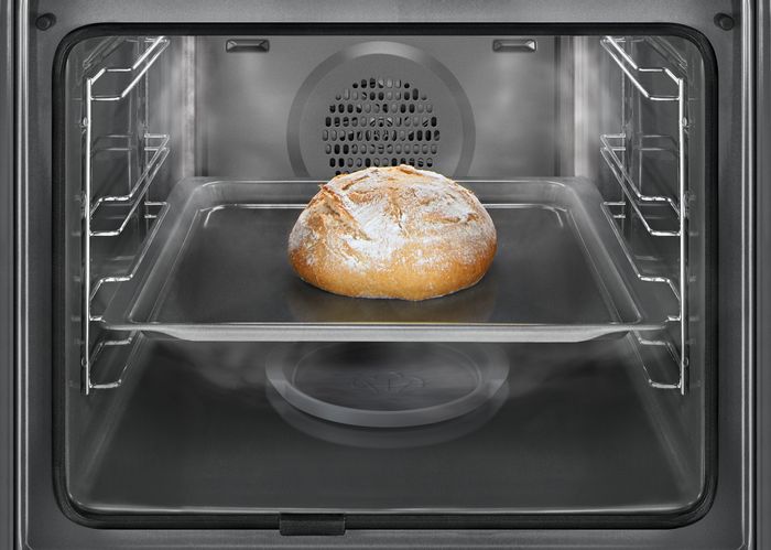 Pane rotondo croccante in cottura su teglia all&rsquo;interno di forno Siemens con funzione addedSteam