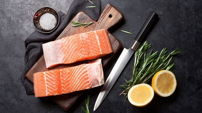 Filetto di salmone crudo su un tagliere pronto per essere marinato e cotto