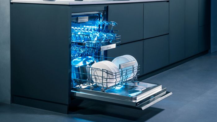 Open dishwasher with plates and glasses