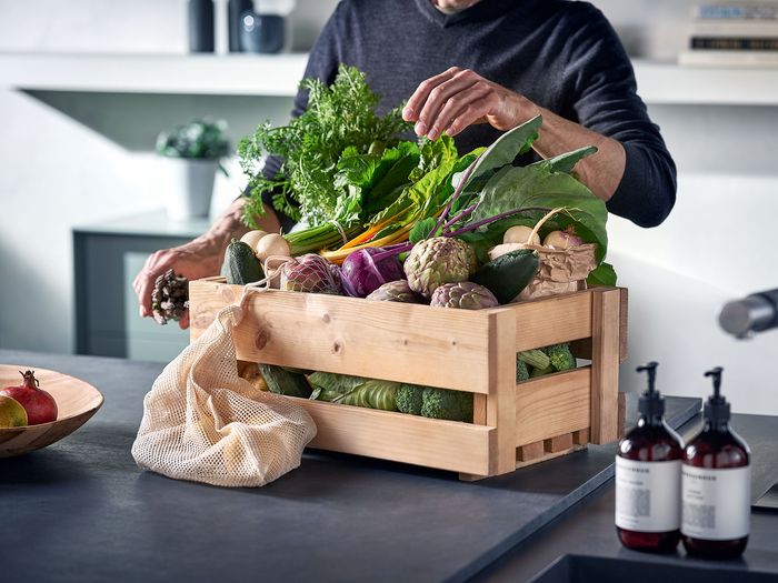 Cassetta di legno con verdure fresche sul bancone della cucina