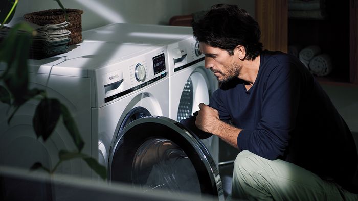 Person loading an connected washing machine