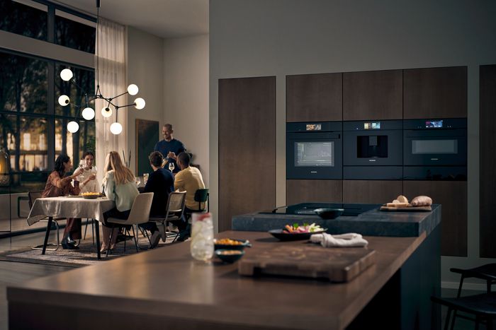 Cucina moderna con elettrodomestici da incasso connessi e zona pranzo open space