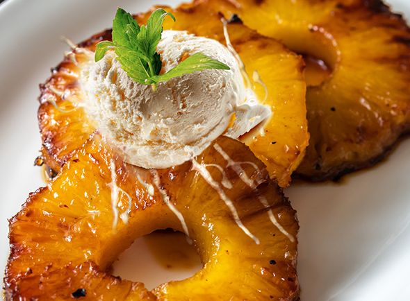 Carmelised, spiced rum pineapple slices with coconut ice cream