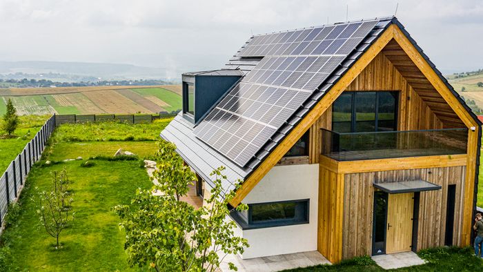 Casa immersa nel verde con il tetto coperto da pannelli fotovoltaici