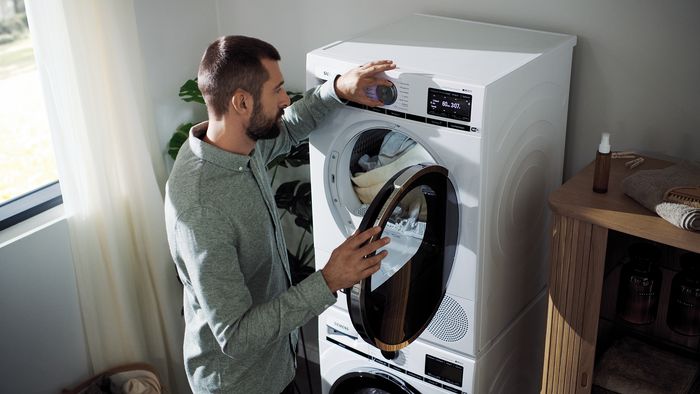 Man adjusting washing machine settings