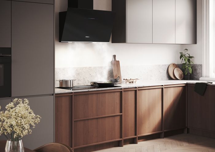 Cappa da parete e piano cottura a induzione Siemens in una cucina moderna, con pentole in cottura