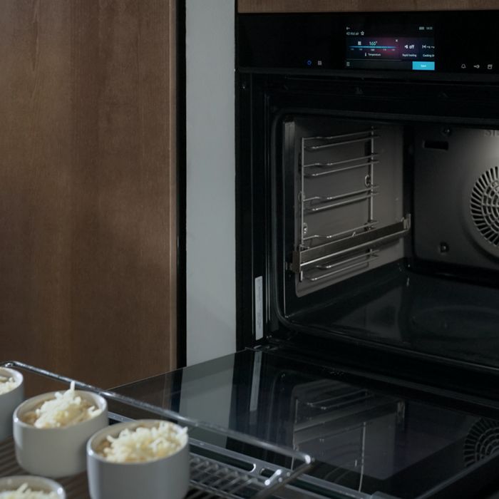 Forno da incasso Siemens con sportello aperto e display che mostra le impostazioni di cottura