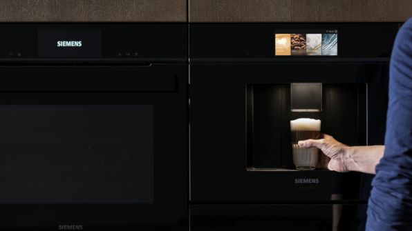 Mano cher prende un caffé appena preparato da una machcina da caffé Siemens integrata