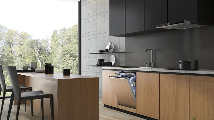 Cocina moderna con paredes de hormig&oacute;n, armarios de madera y gran ventana con vistas a la naturaleza.