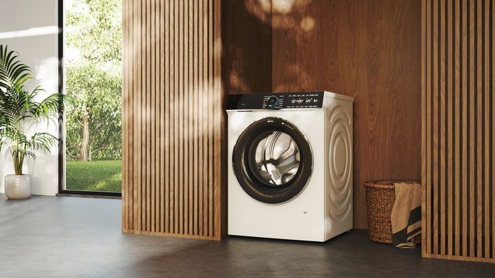 Mann bedient iQ700 Premium Waschmaschine von Siemens